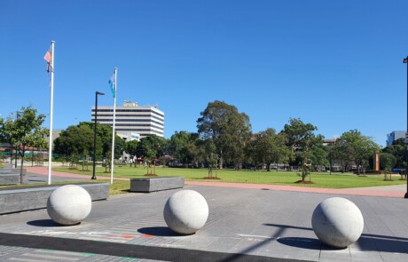 A photo of a community recreation area with a park and buildings in the background