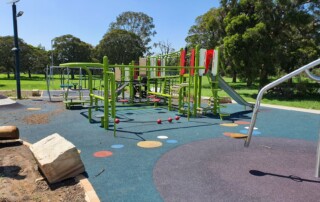 A photo of an outdoor play equipment area within a larger park